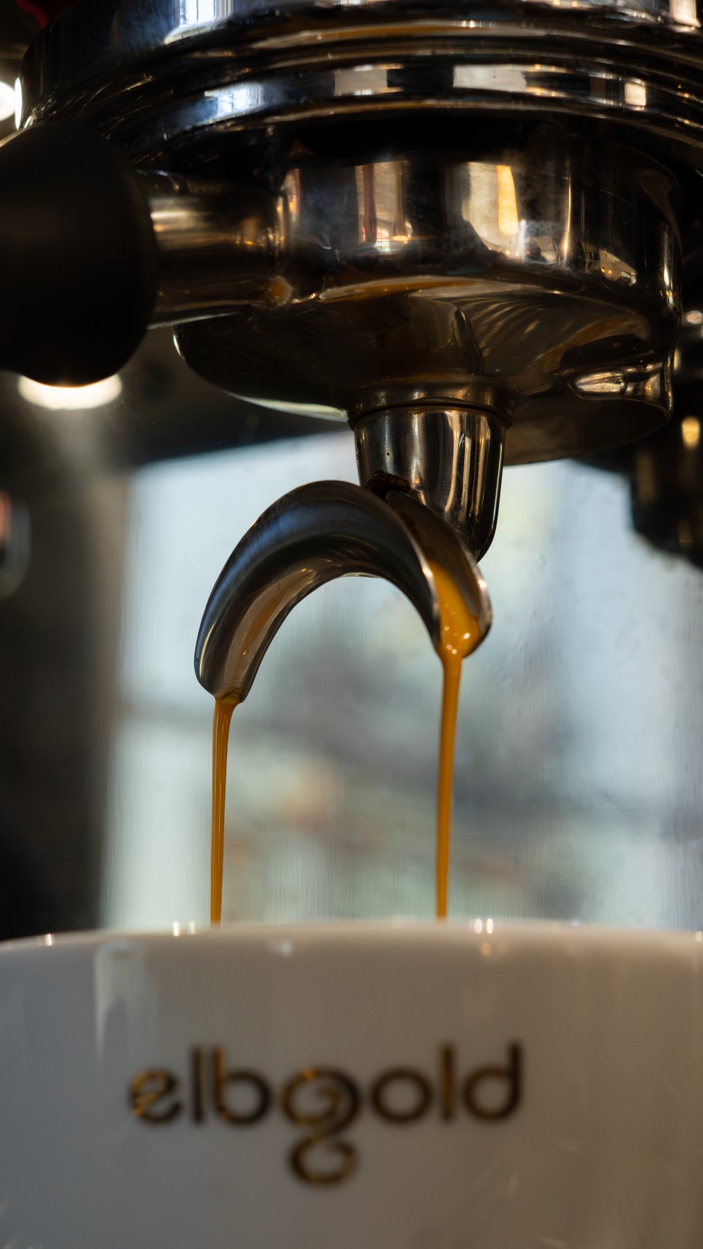 Espresso läuft in eine elbgold-Tasse