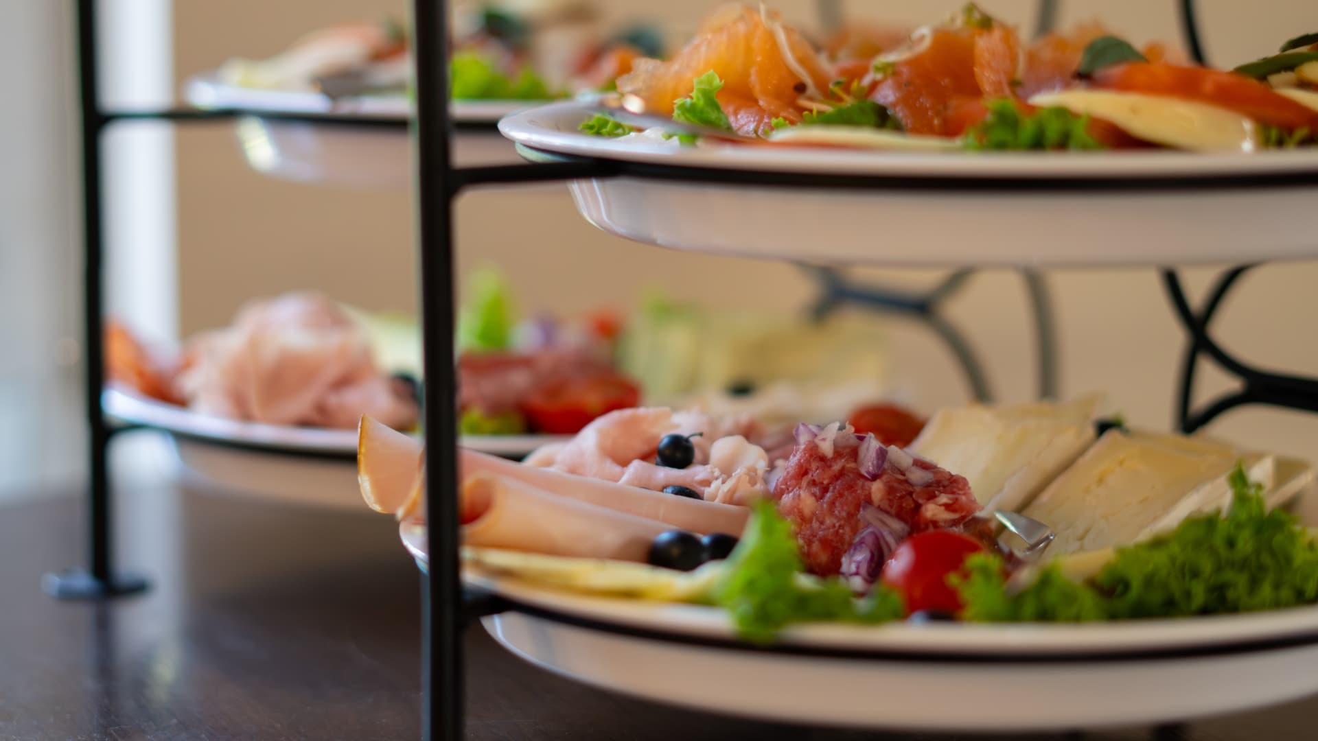 Etagere mit Lachs, Aufschnitt, Käse und frischem Gemüse